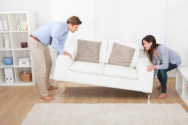 A couple moving a chair in their apartment