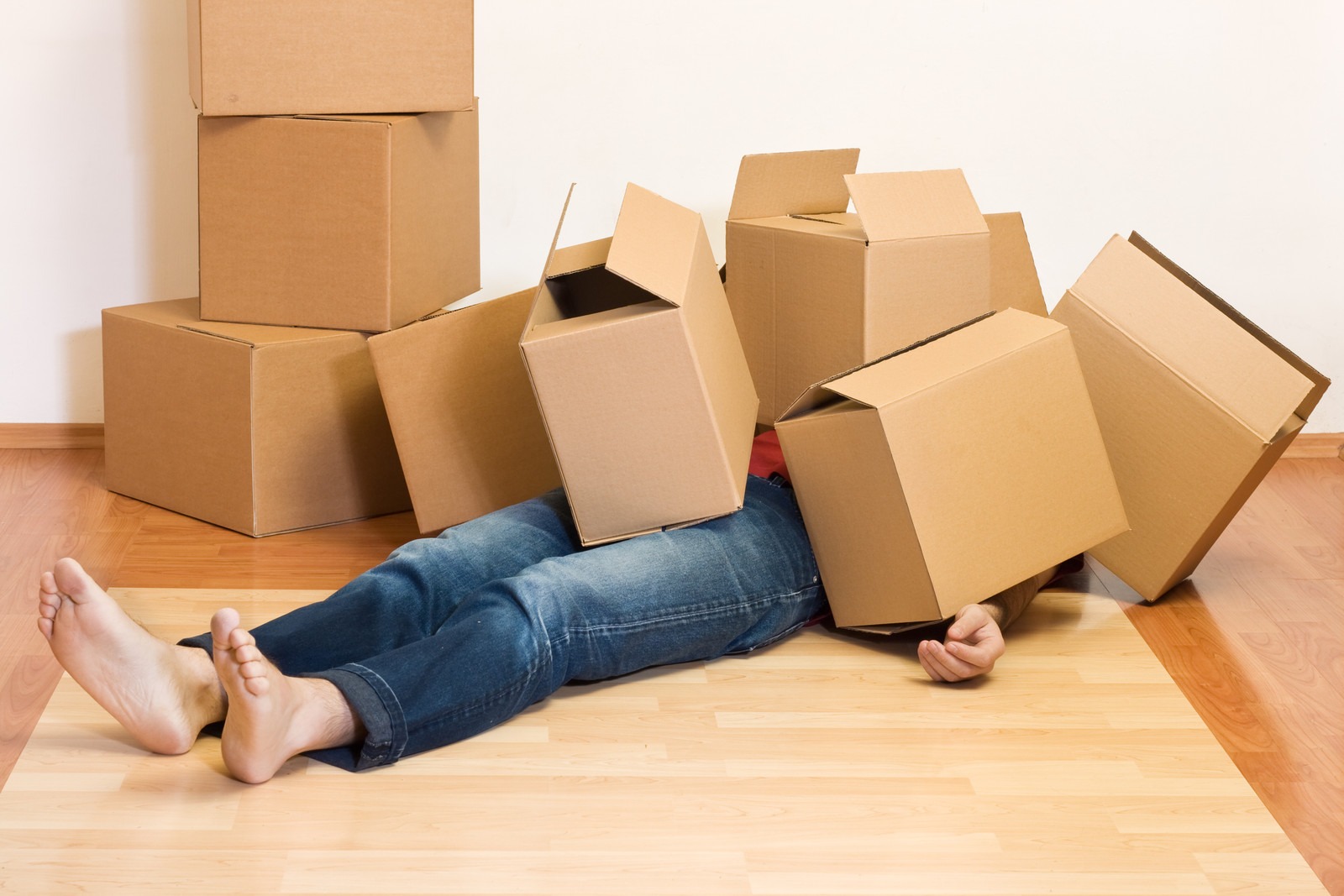 man under a pile of cardboard boxes