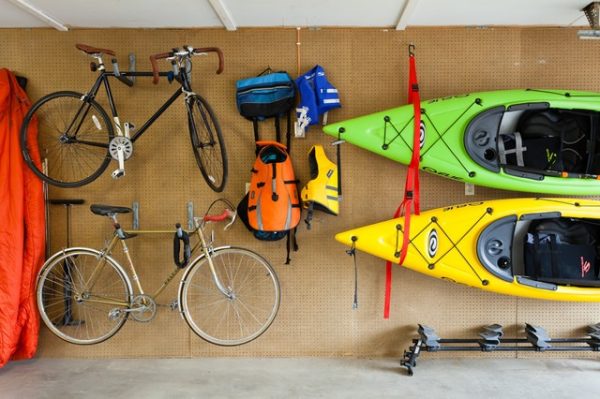 A wooden shelf stacked with mountain bukes and kayaks